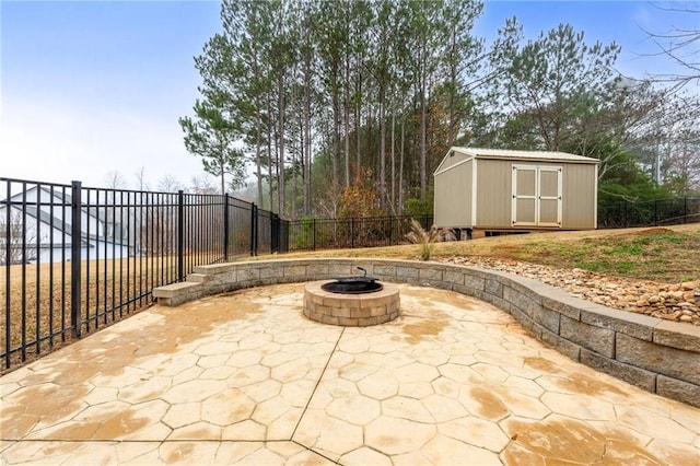 view of patio / terrace with a storage unit, a fire pit, an outdoor structure, and a fenced backyard