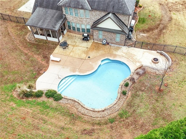 view of pool featuring a fenced in pool, a fenced backyard, a sunroom, a fire pit, and a patio area