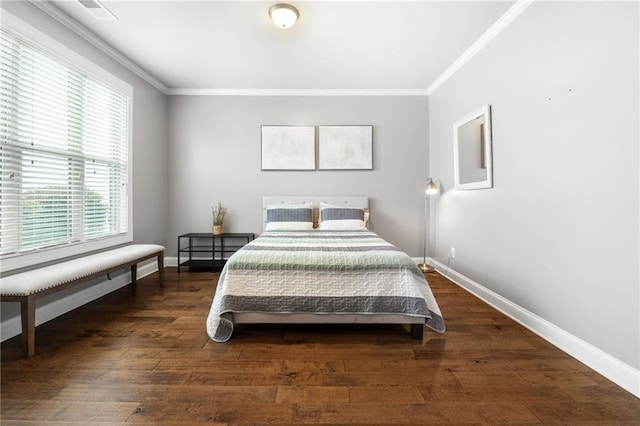 bedroom with crown molding, baseboards, and wood finished floors