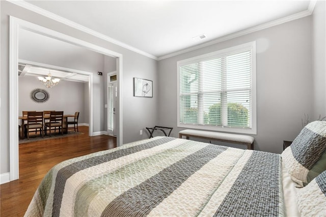 bedroom featuring crown molding, wood finished floors, visible vents, and baseboards