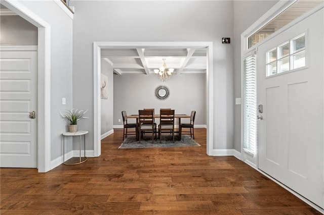 foyer featuring dark wood-type flooring, baseboards, a chandelier, beamed ceiling, and coffered ceiling