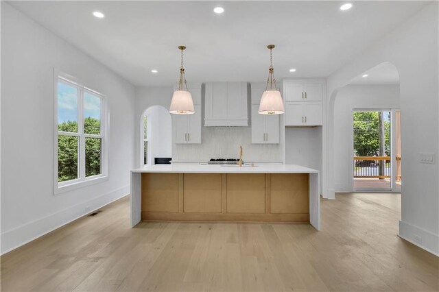 380 Hillcrest View Dr, Suwanee, GA 30024 - kitchen with wall chimney exhaust hood, arched walkways, recessed lighting, white cabinets, and light countertops