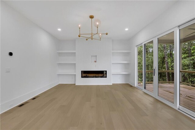 380 Hillcrest View Dr, Suwanee, GA 30024 - unfurnished living room featuring a chandelier, light wood-style floors, baseboards, built in shelves, and a fireplace