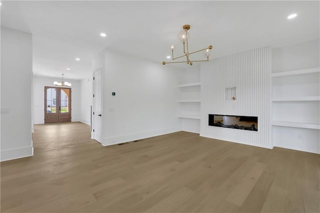 380 Hillcrest View Dr, Suwanee, GA 30024 - unfurnished living room featuring a chandelier, baseboards, wood finished floors, built in shelves, and recessed lighting