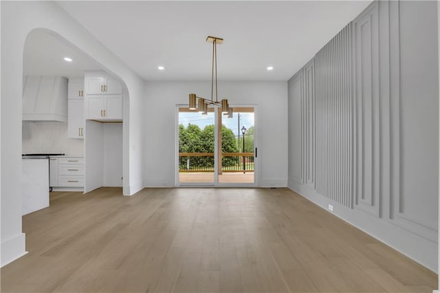 380 Hillcrest View Dr, Suwanee, GA 30024 - unfurnished dining area featuring light wood-style flooring, arched walkways, and recessed lighting