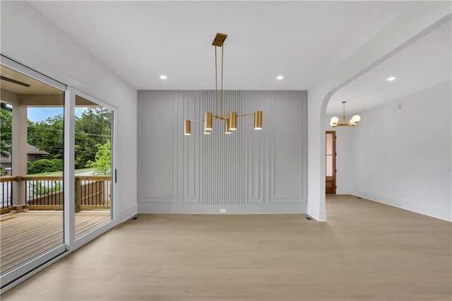 380 Hillcrest View Dr, Suwanee, GA 30024 - unfurnished dining area with a chandelier, light wood finished floors, baseboards, recessed lighting, and arched walkways