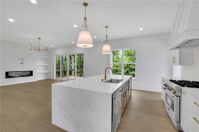 380 Hillcrest View Dr, Suwanee, GA 30024 - kitchen featuring gas range, a sink, custom range hood, stainless steel dishwasher, and light wood-style flooring