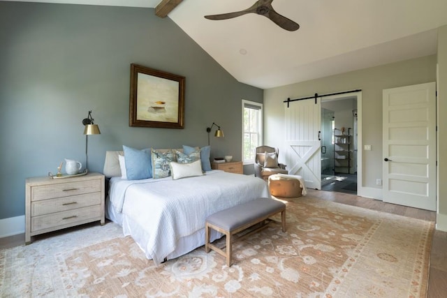 bedroom with lofted ceiling with beams, light hardwood / wood-style floors, a barn door, and ceiling fan