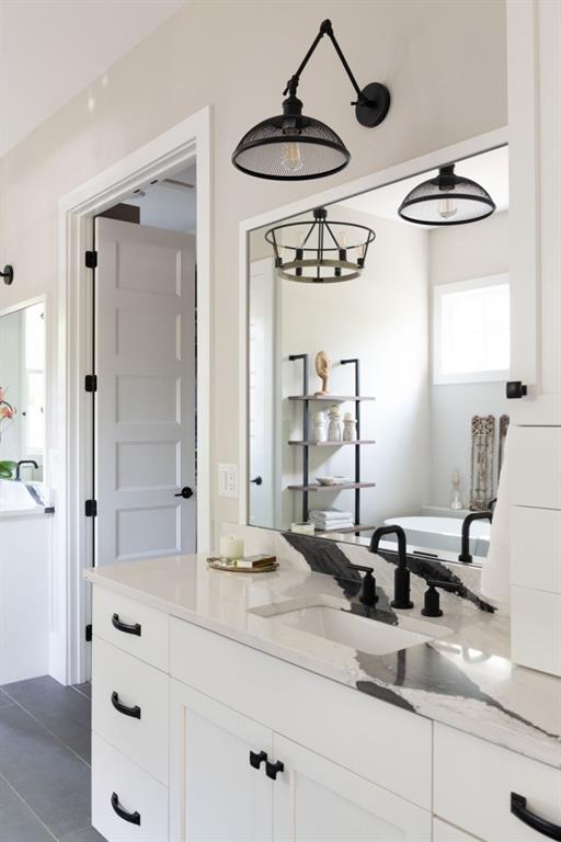 bathroom featuring tile patterned flooring, vanity, and a bathing tub