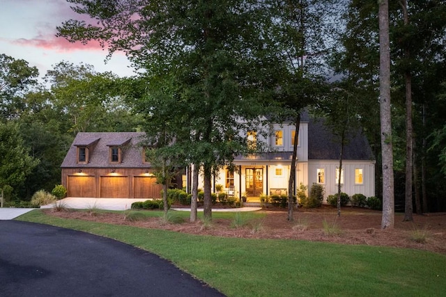 view of front of home with a garage, a balcony, and a lawn