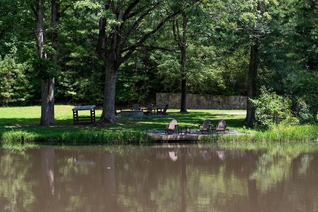 view of property's community featuring a water view, a yard, and a fire pit