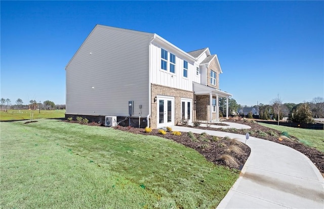 view of side of property featuring a lawn and french doors