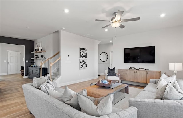 living room featuring ceiling fan and light hardwood / wood-style floors