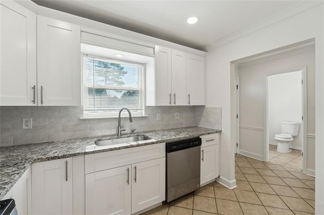 kitchen with white cabinetry, stainless steel dishwasher, sink, and light stone counters