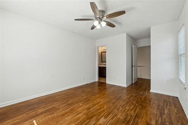 unfurnished bedroom featuring ceiling fan, ensuite bathroom, and dark hardwood / wood-style flooring