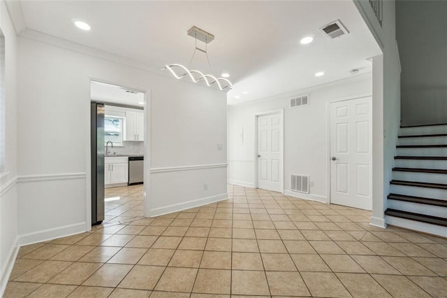 tiled spare room featuring sink, crown molding, and a chandelier