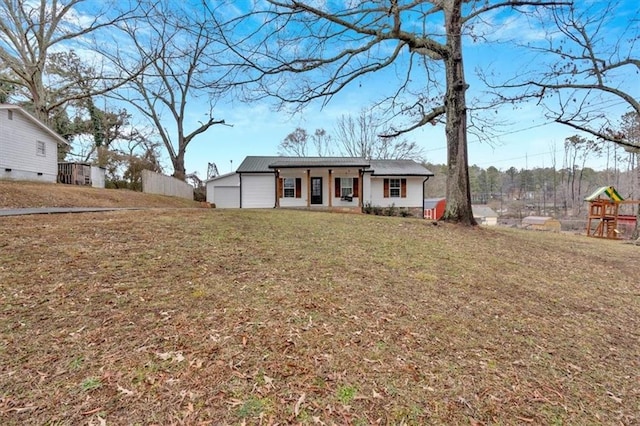 view of front facade with a garage, a playground, and a front lawn