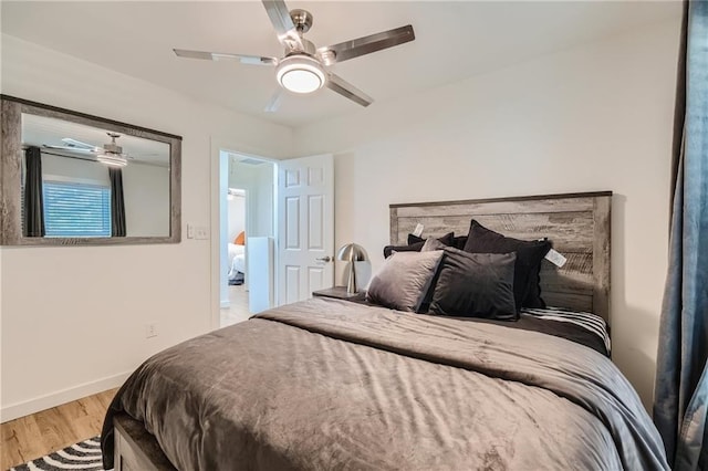 bedroom featuring a ceiling fan, baseboards, and wood finished floors
