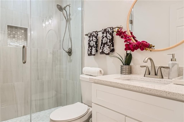 bathroom featuring vanity, a shower stall, and toilet