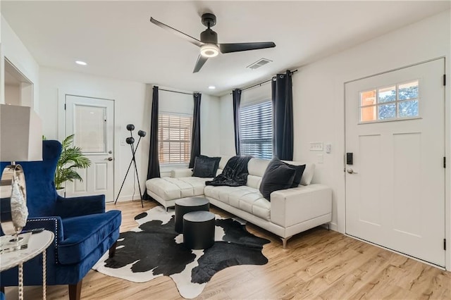 living area with light wood-type flooring, ceiling fan, visible vents, and recessed lighting