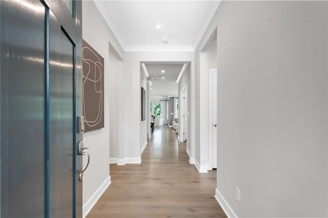 hallway featuring ornamental molding and light hardwood / wood-style flooring