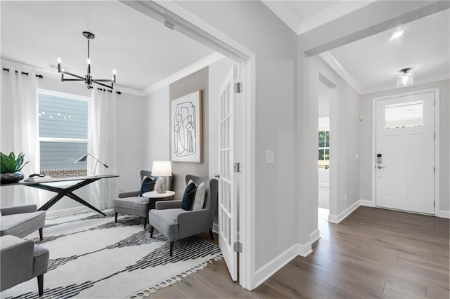 entryway featuring hardwood / wood-style flooring, a notable chandelier, and ornamental molding