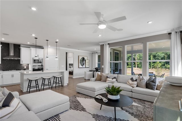 living room with ornamental molding, ceiling fan, and dark hardwood / wood-style floors