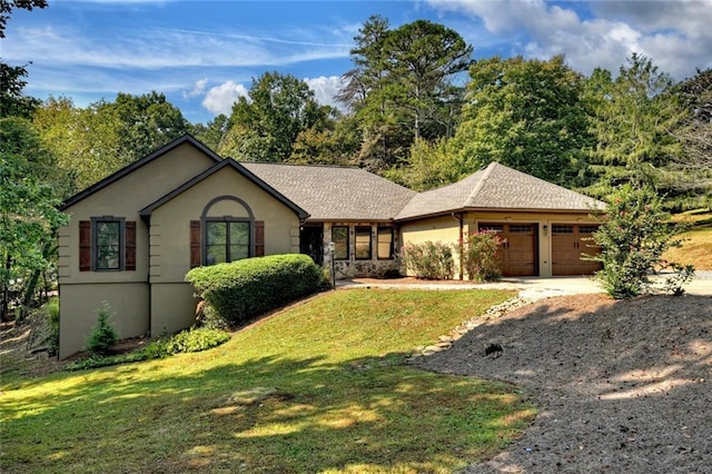 ranch-style house with a front lawn, driveway, an attached garage, and stucco siding