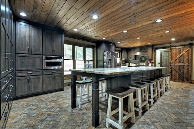 kitchen featuring wood ceiling, a barn door, appliances with stainless steel finishes, and recessed lighting