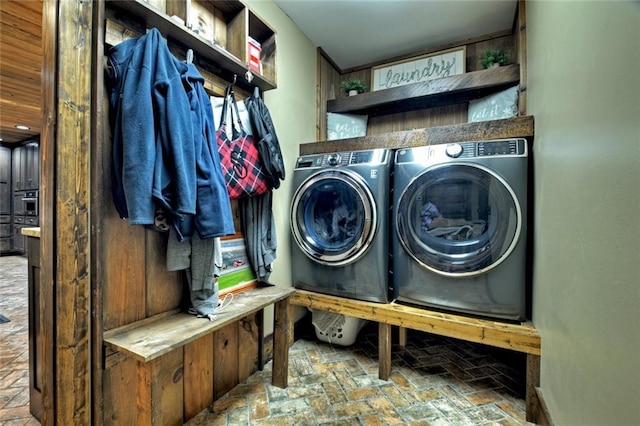 laundry area featuring brick floor, laundry area, and separate washer and dryer