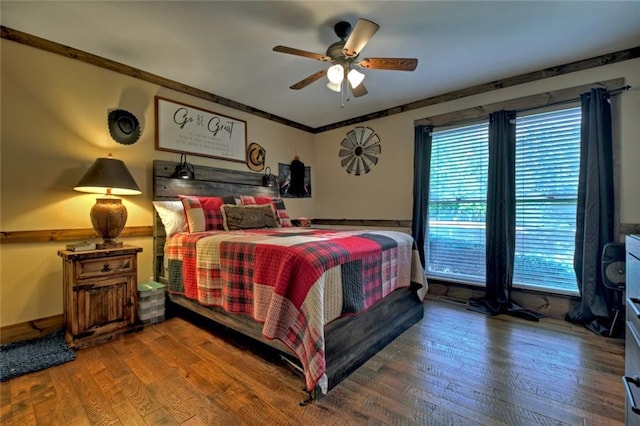 bedroom featuring ceiling fan, multiple windows, wood finished floors, and crown molding