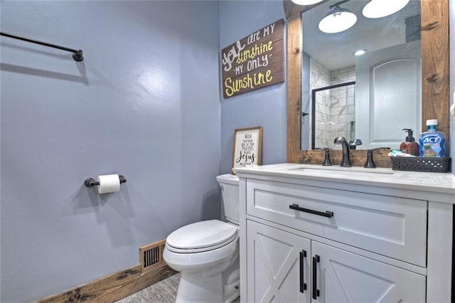 full bathroom featuring toilet, visible vents, vanity, baseboards, and a shower stall