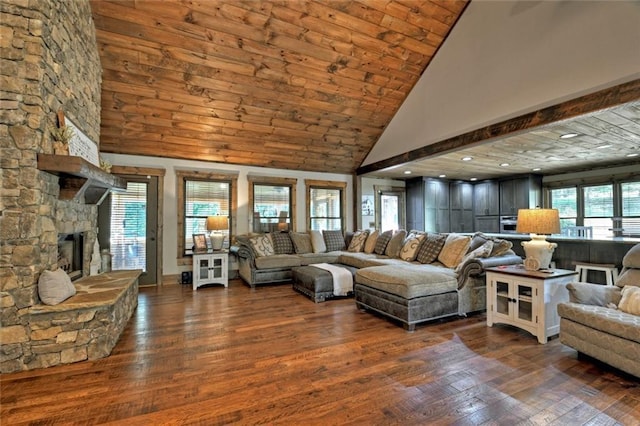 living room with high vaulted ceiling, a fireplace, and wood finished floors