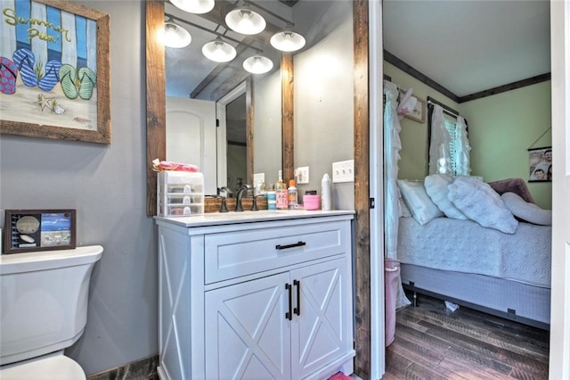 bathroom with toilet, wood finished floors, vanity, ensuite bath, and crown molding