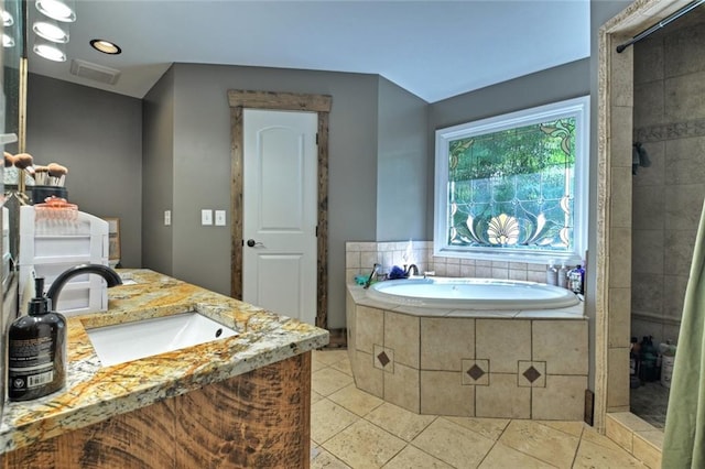 full bathroom with visible vents, a sink, a bath, and tile patterned floors