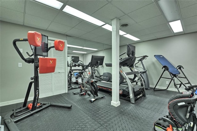 exercise room featuring a drop ceiling, visible vents, and baseboards