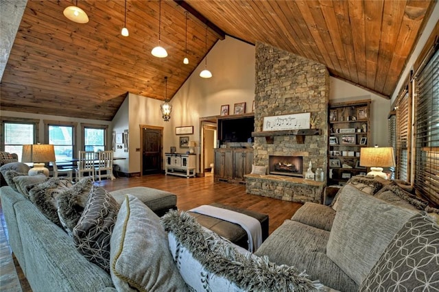 living area with high vaulted ceiling, a fireplace, wood finished floors, and wooden ceiling