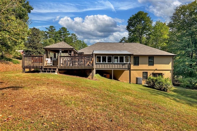 back of property with a lawn, cooling unit, a wooden deck, and stucco siding