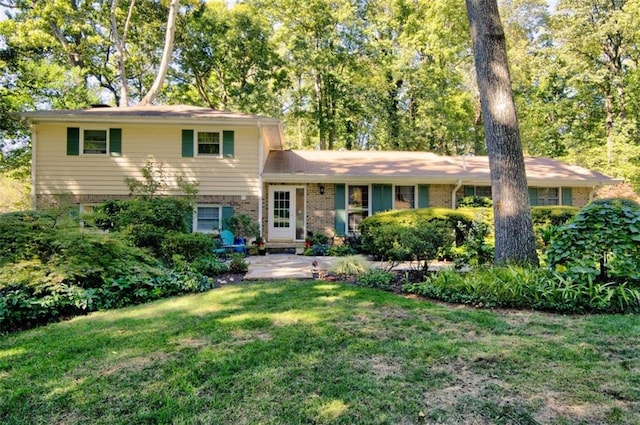 split level home with a front yard and brick siding