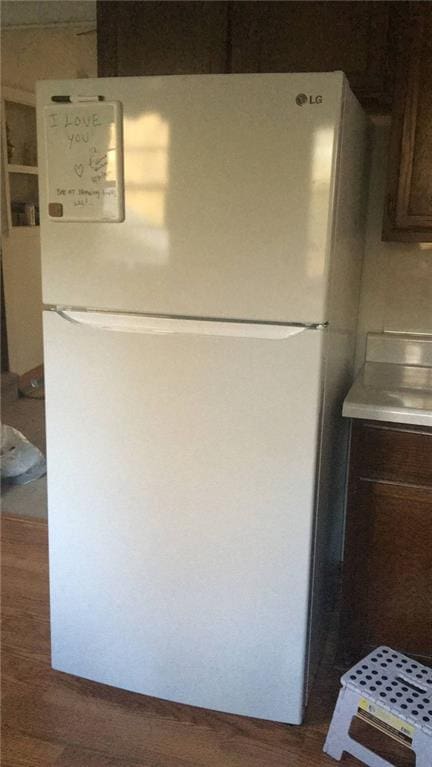 room details featuring white refrigerator, dark hardwood / wood-style flooring, and dark brown cabinetry