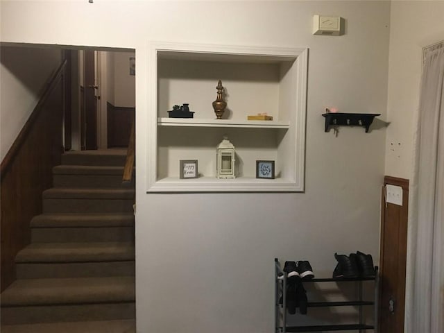 stairs featuring built in shelves