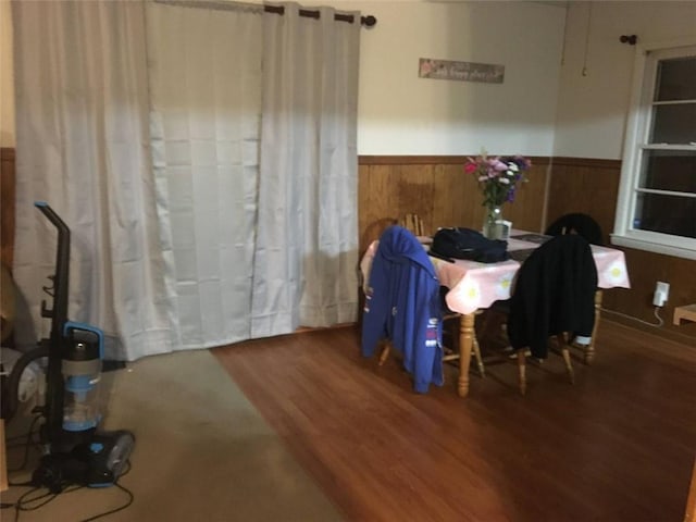 dining room with hardwood / wood-style flooring and wood walls