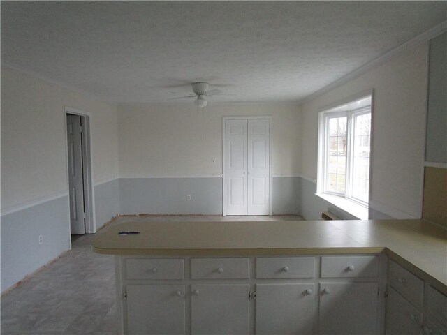 kitchen featuring white cabinetry, light countertops, and ceiling fan