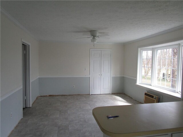 interior space featuring tile patterned floors, a textured ceiling, an AC wall unit, and ceiling fan