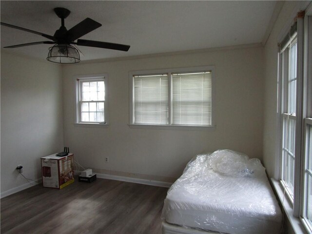unfurnished bedroom with wood finished floors, baseboards, and ornamental molding