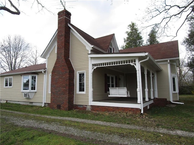 view of home's exterior featuring crawl space, a porch, and a chimney