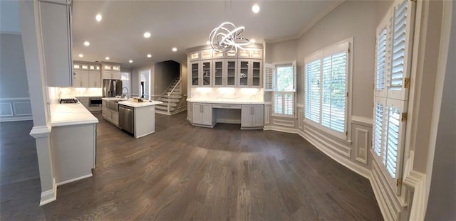 255 Carriage Station Dr, Lawrenceville, GA 30046 - kitchen featuring stainless steel appliances, a kitchen island with sink, a decorative wall, light countertops, and crown molding