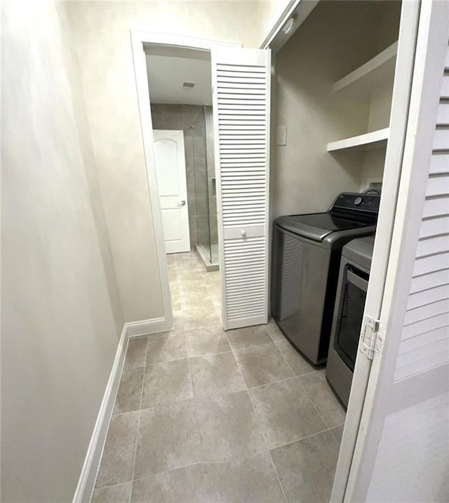 255 Carriage Station Dr, Lawrenceville, GA 30046 - laundry room featuring washing machine and dryer, light tile patterned floors, and baseboards