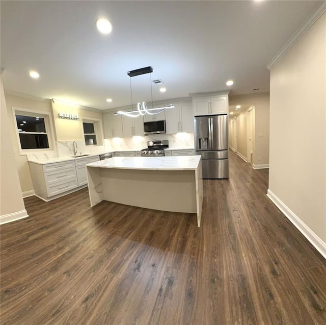 255 Carriage Station Dr, Lawrenceville, GA 30046 - kitchen featuring stainless steel appliances, a sink, a kitchen island, baseboards, and white cabinets