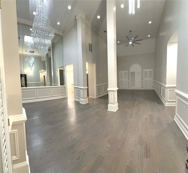 255 Carriage Station Dr, Lawrenceville, GA 30046 - unfurnished living room featuring a high ceiling, ceiling fan, dark wood-style flooring, a decorative wall, and decorative columns